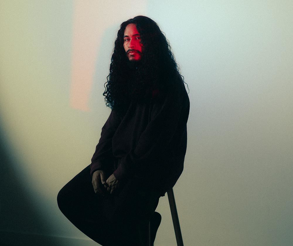Man with long hair and beard sitting on a chair