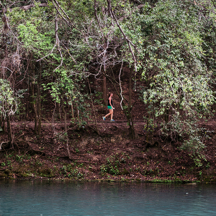 Woman walking in the jungle with lake