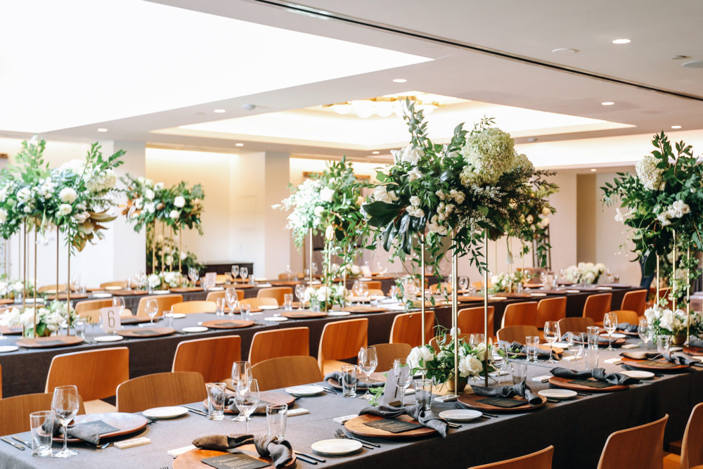 A big hall with dining tables and dishes with decorated plants and flowers