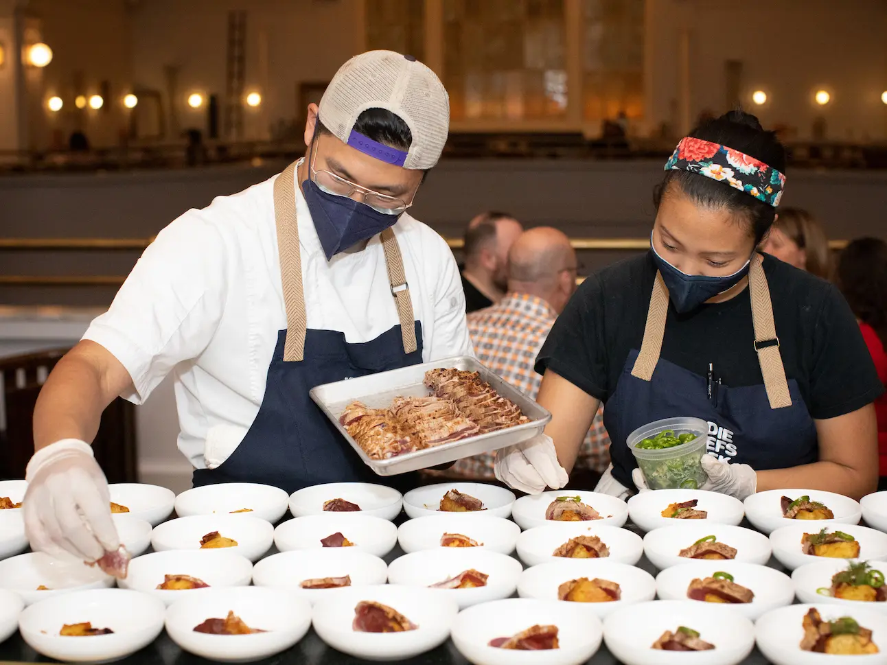 a lady and a guy arranging food in the bowls