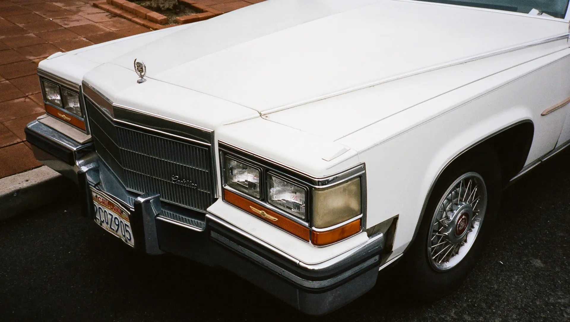 White 1987 cadillac brougham parked in a road