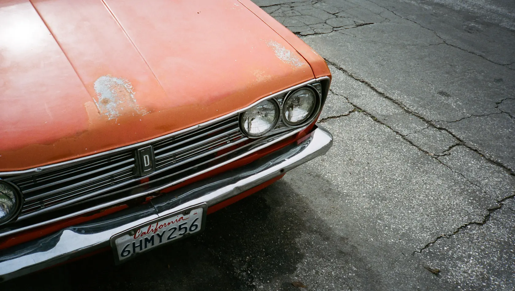 Orange datsun 510 parked in a road