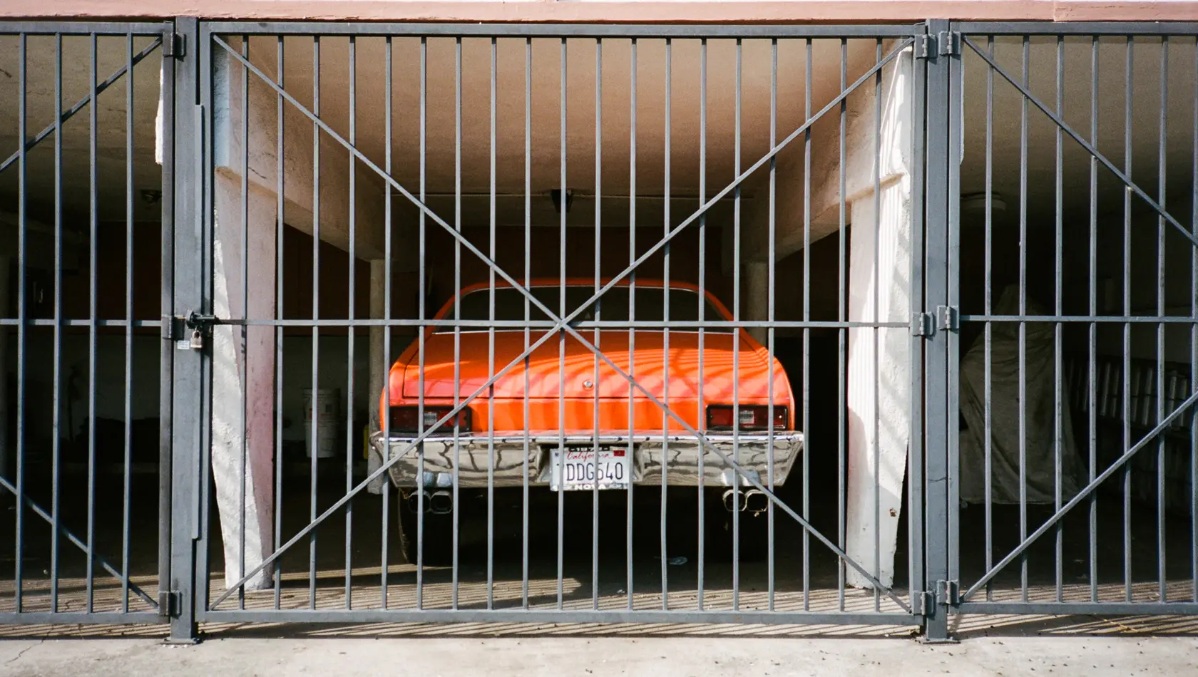 Orange datsun 510 parked inside the garage