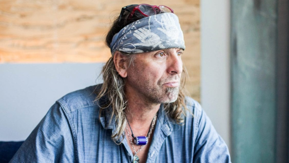 Man wearing blue jacket and head bandana