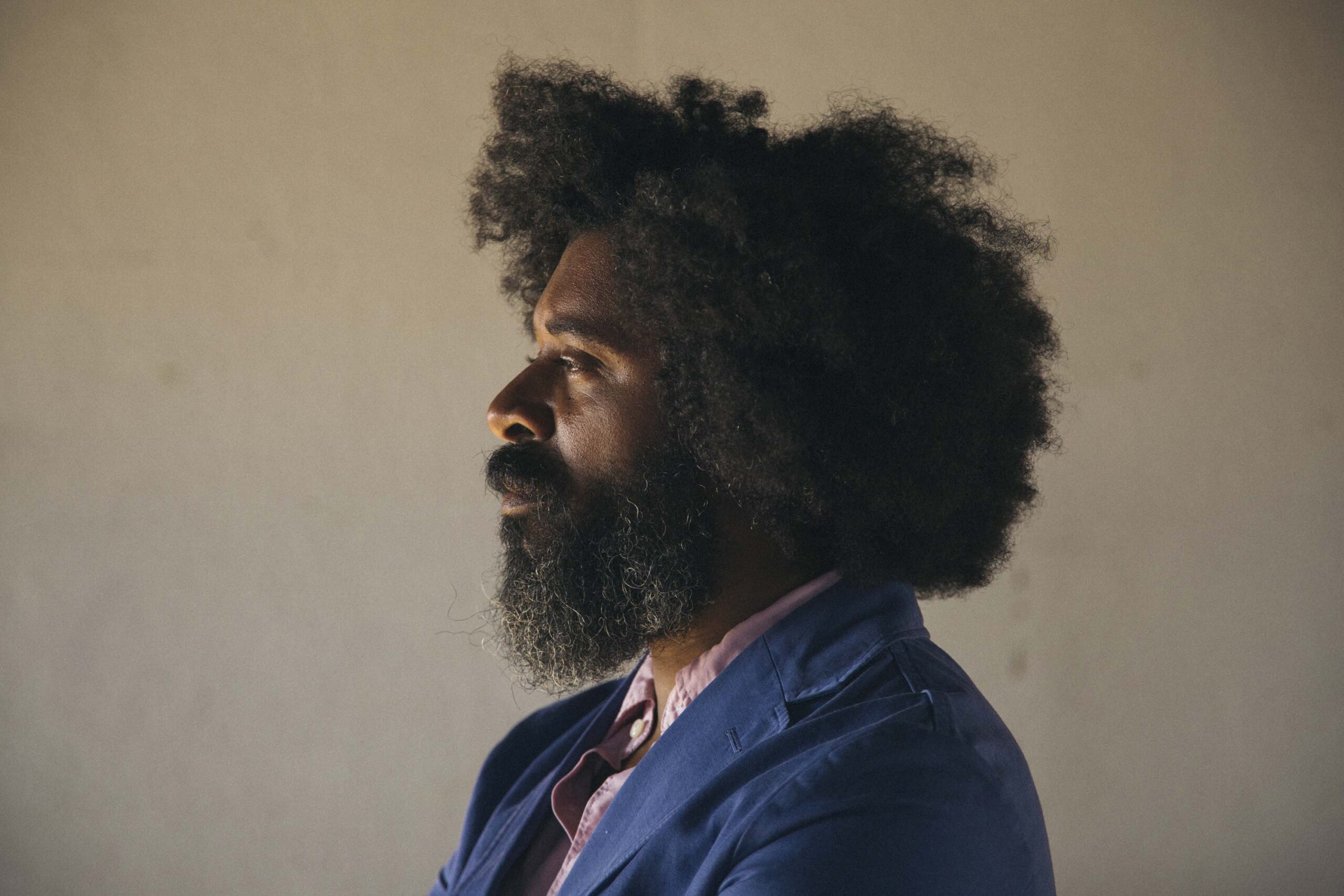 A man with curly hair looking to the left side.