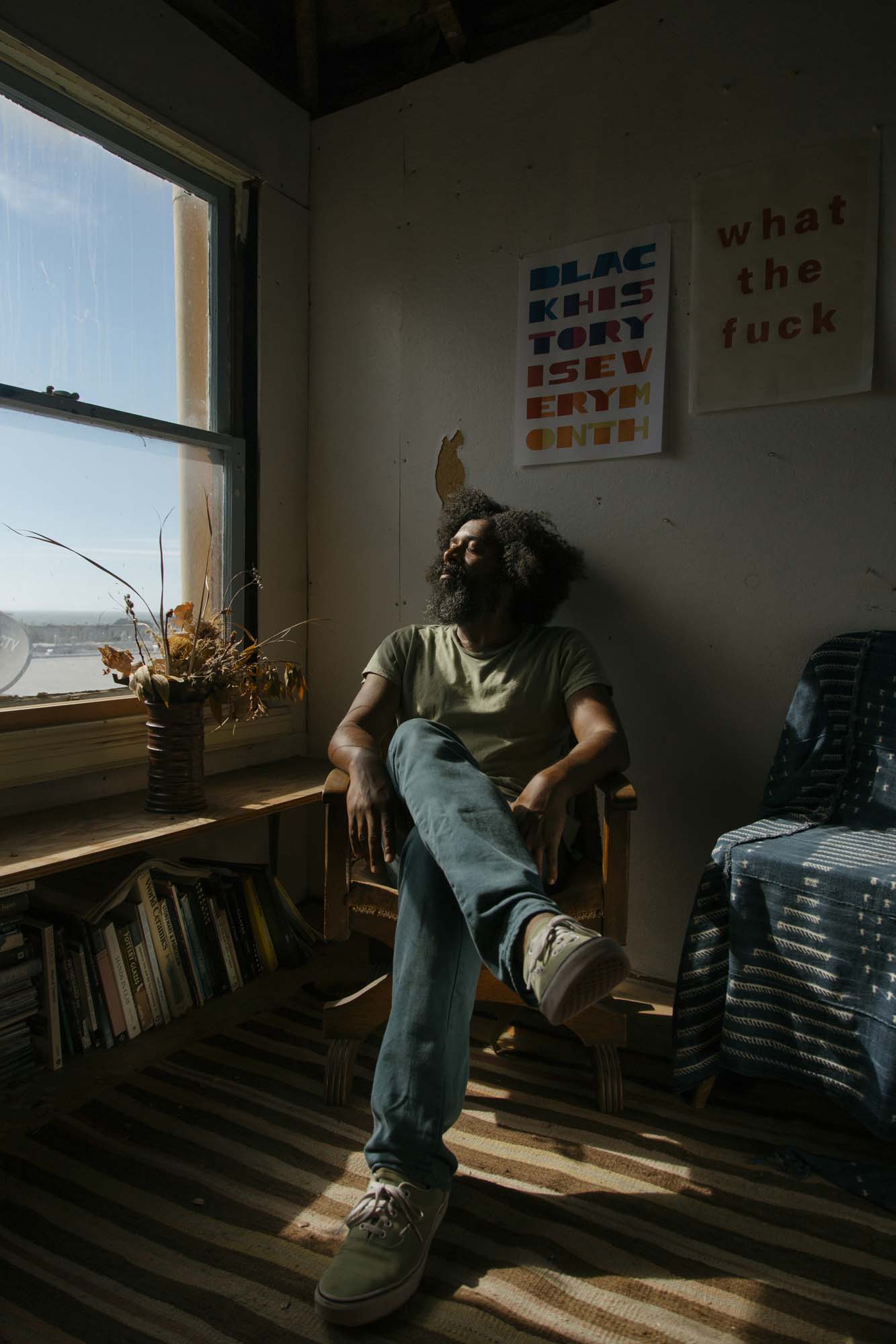 A seated artist is gazing out of the window.