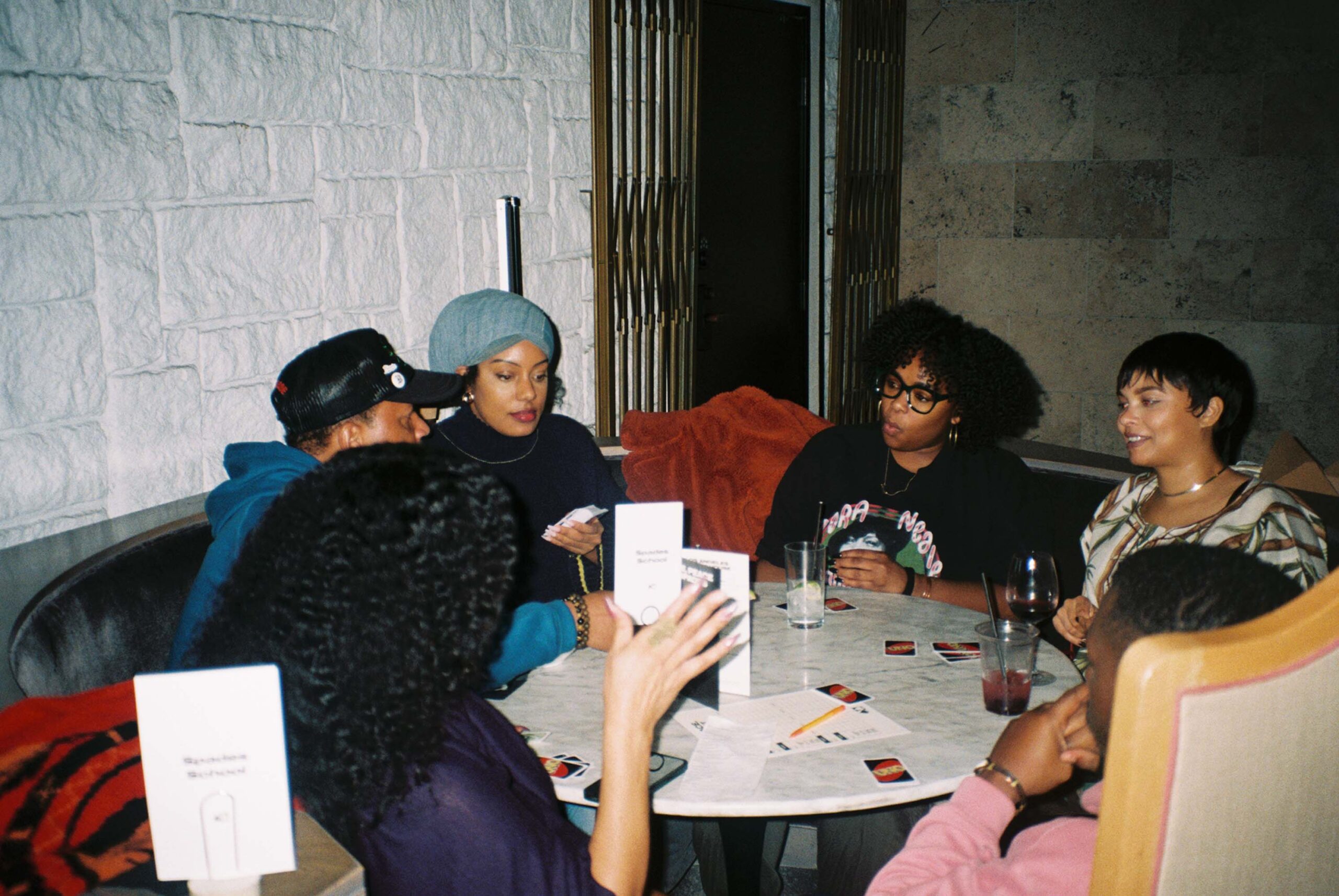 People sit at a round table playing Uno