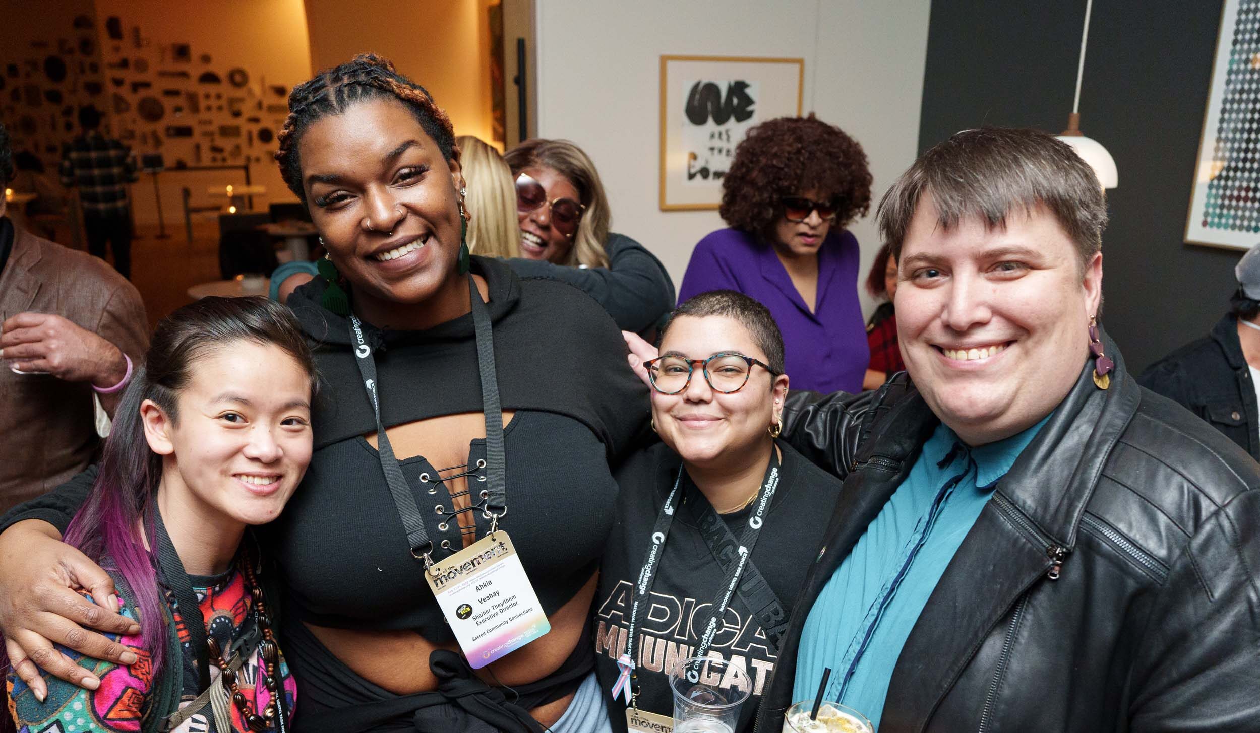 A diverse group of people hug and smile at the camera