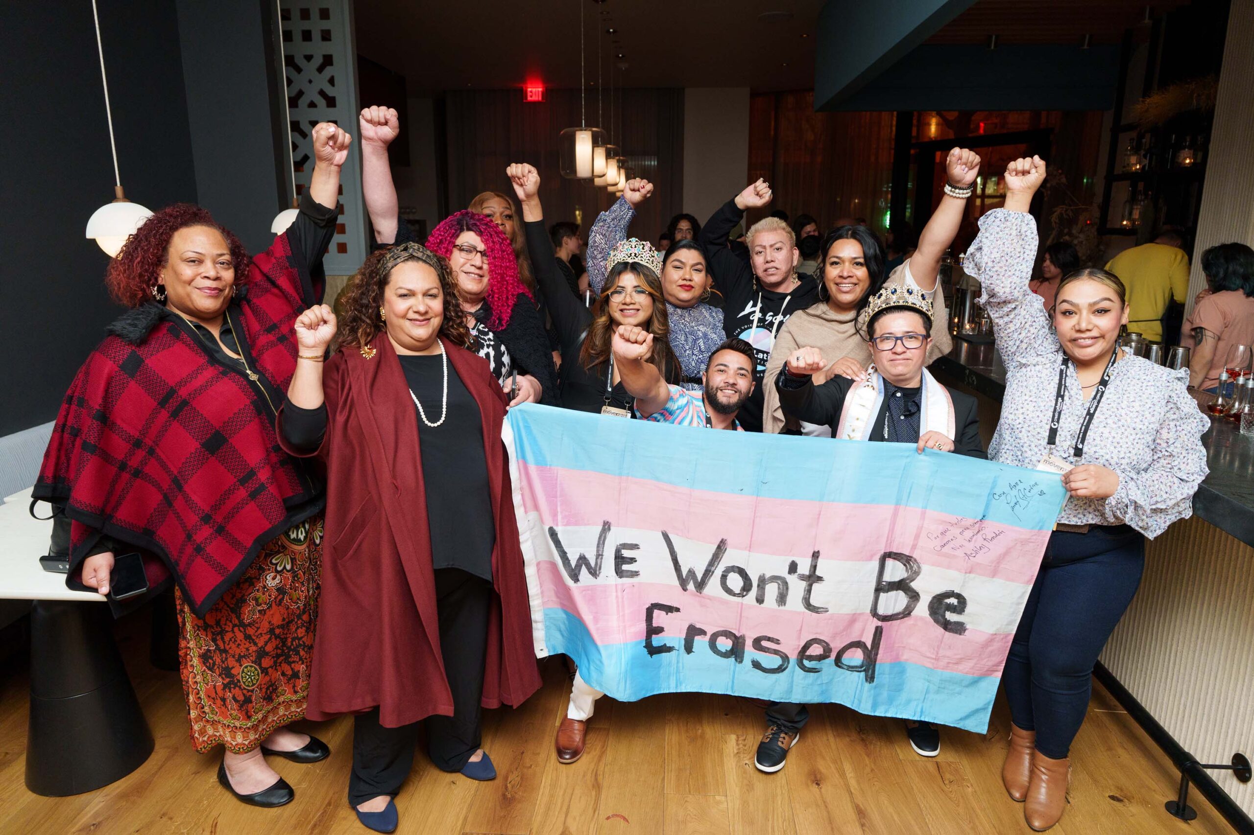 A group of people hold a banner and have their fists in the air