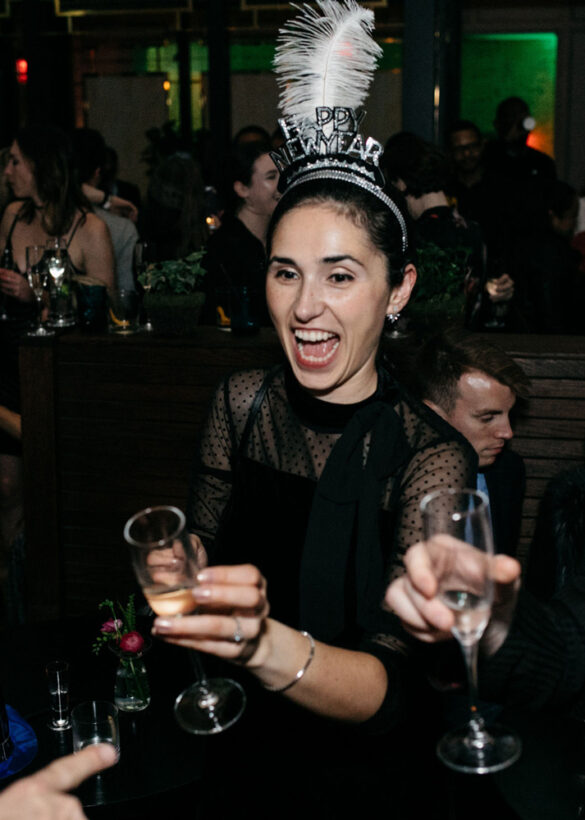 Partygoers in black dresses savor cocktails, adding glamour and enjoyment to the celebration.