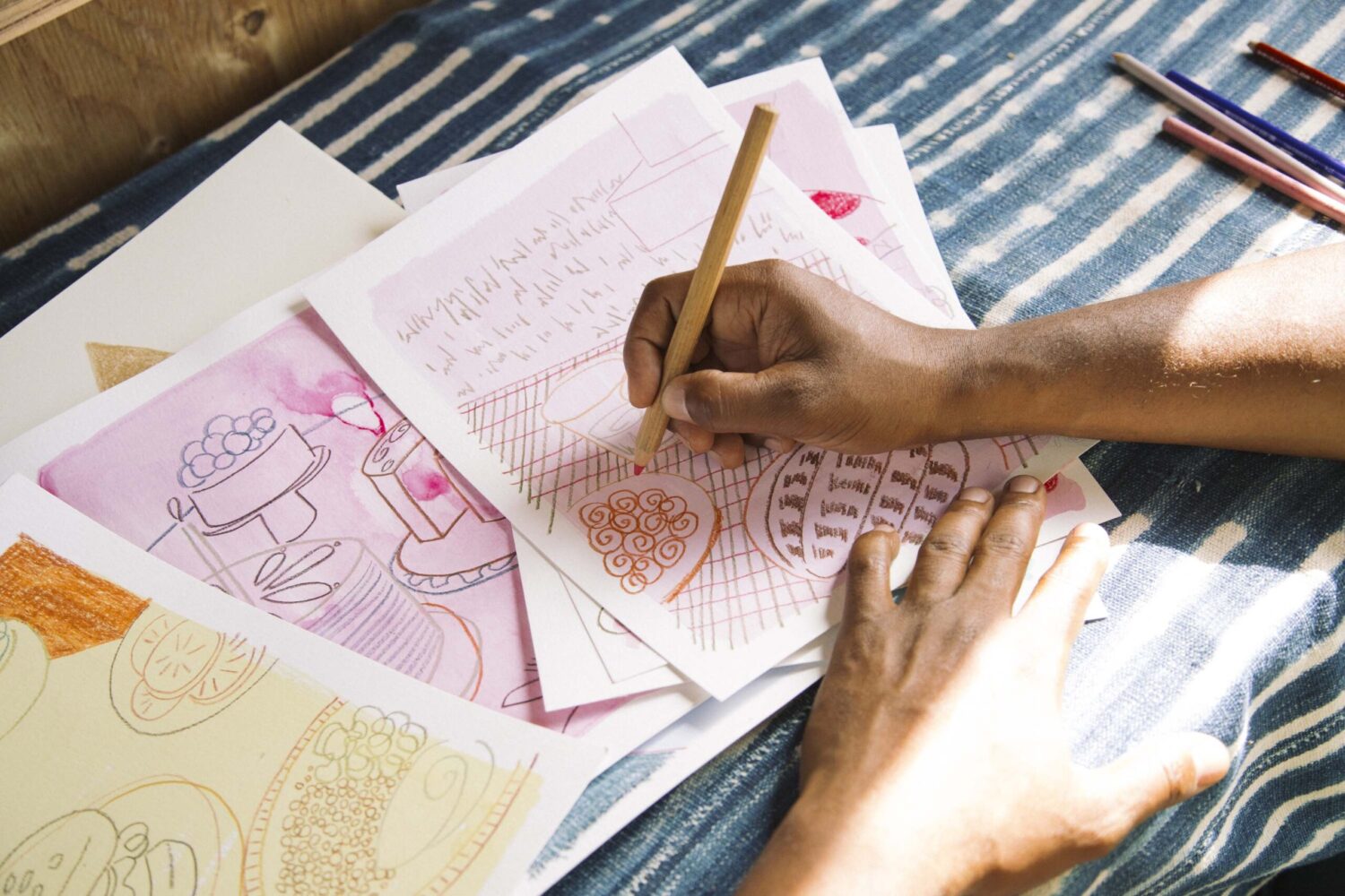 A hand is trying to sketch some diagrams on the paper carefully.