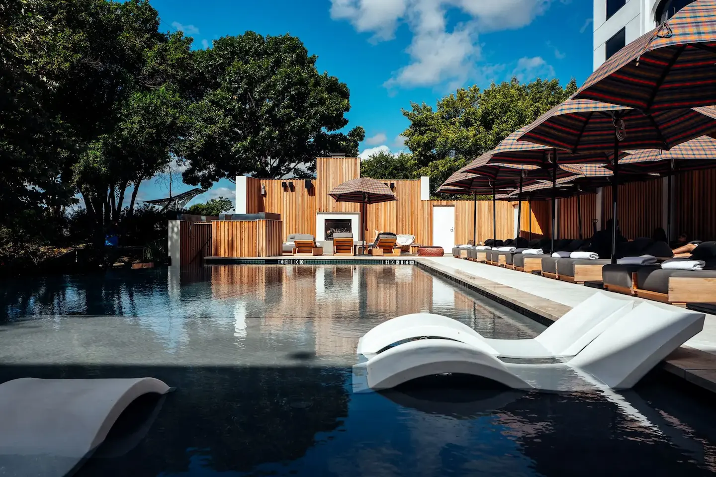 A pool with lounge chairs and umbrellas