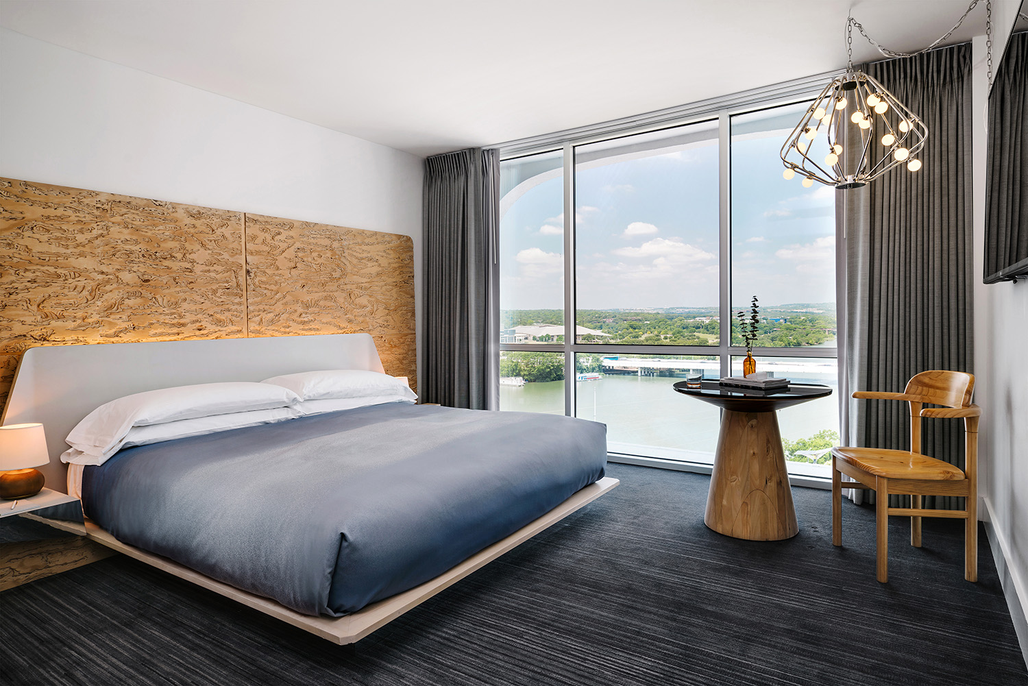 A room with king bed with window to the lakeside view at the LINE Austin