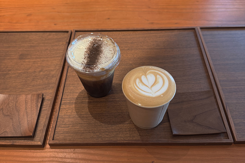 two cups of brown beverage on a wooden tray