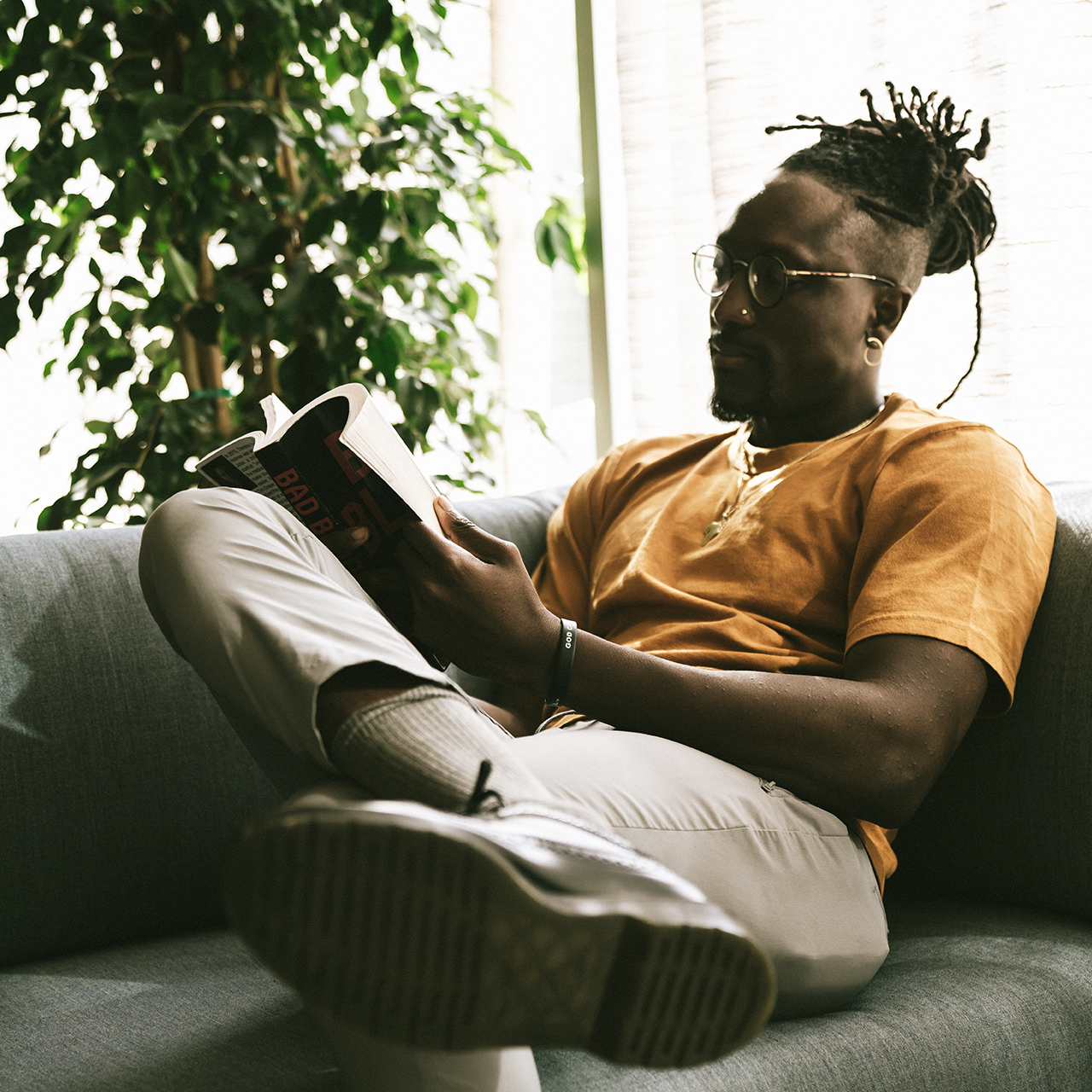 Man laying in the sofa and reading book