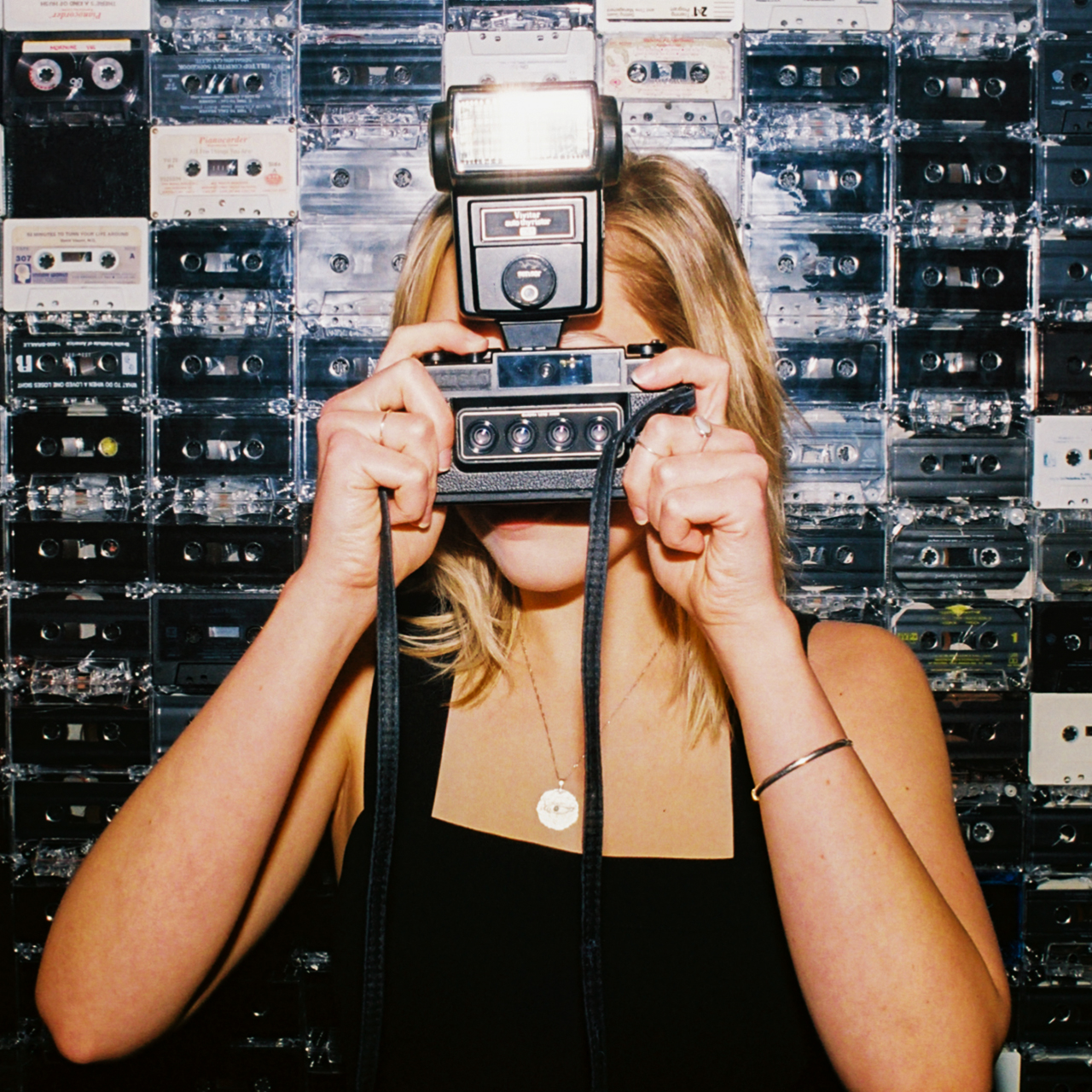 Woman clicking photo with the tape cassette wall