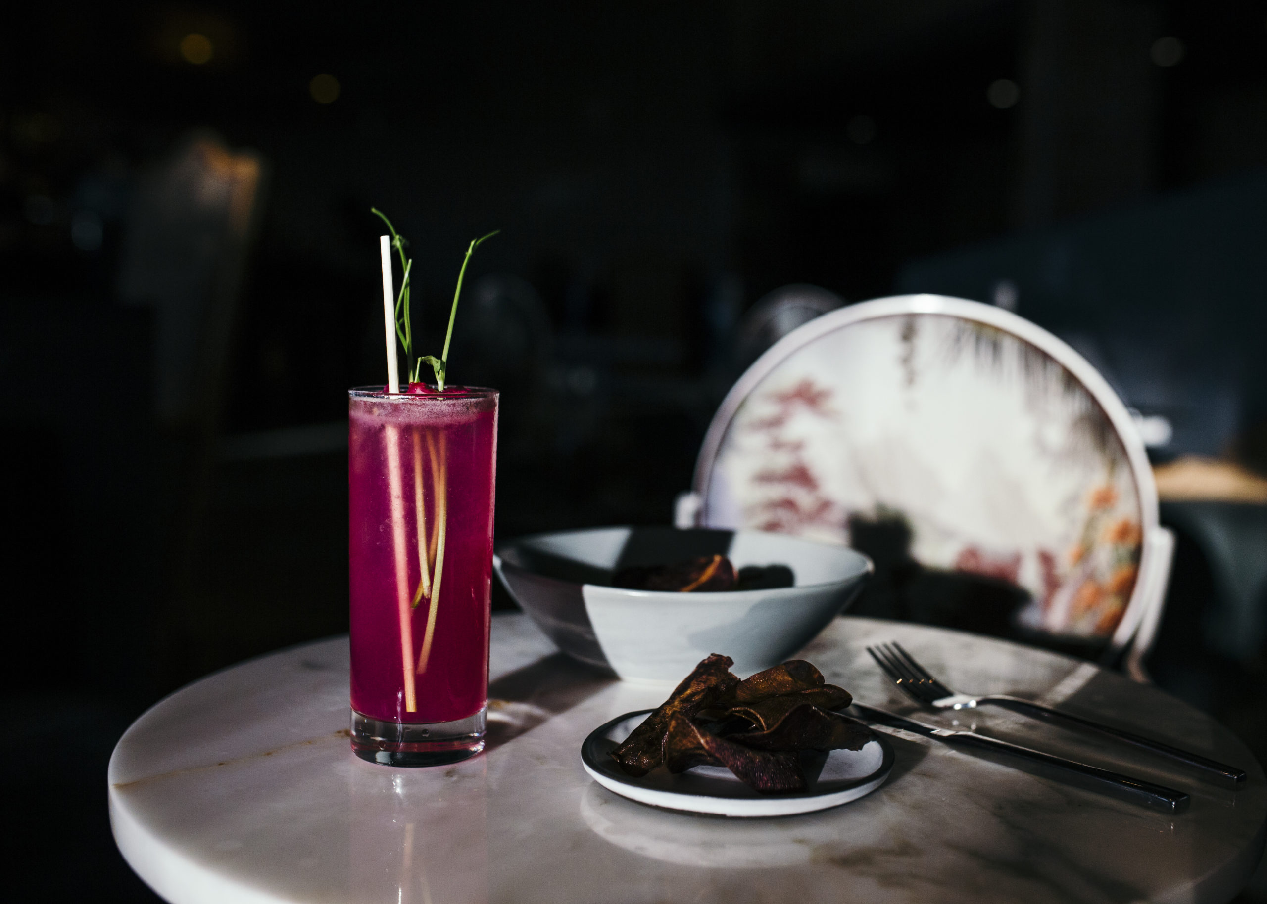 Drink of a glass on the white table with some snacks