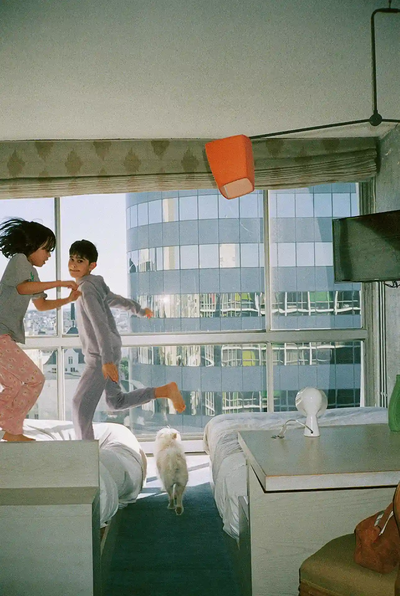 더 라인 LA에서 장난기 가득한 가족, 반려견과 함께 호텔 침대에서 뛰어노는 아이들이 롱 플레이 장기 숙박 혜택을 강조하고 있습니다.