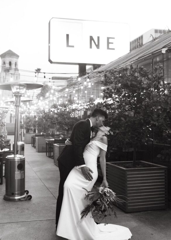 Black and white photo of a couple kissing and holding boutique