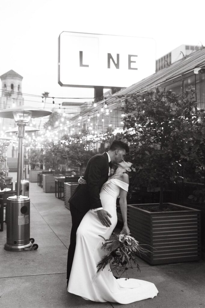 Black and white photo of a couple kissing and holding boutique