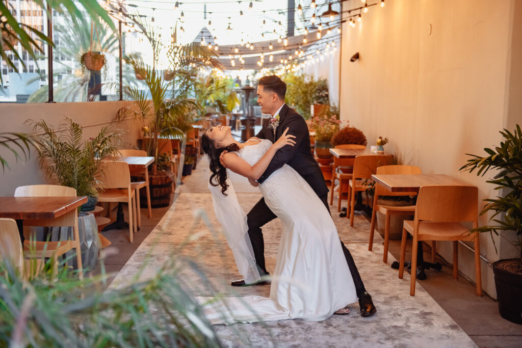 Married couple is posing with chair table in the background