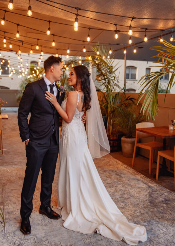 Couple posing with table chair in the background and lights