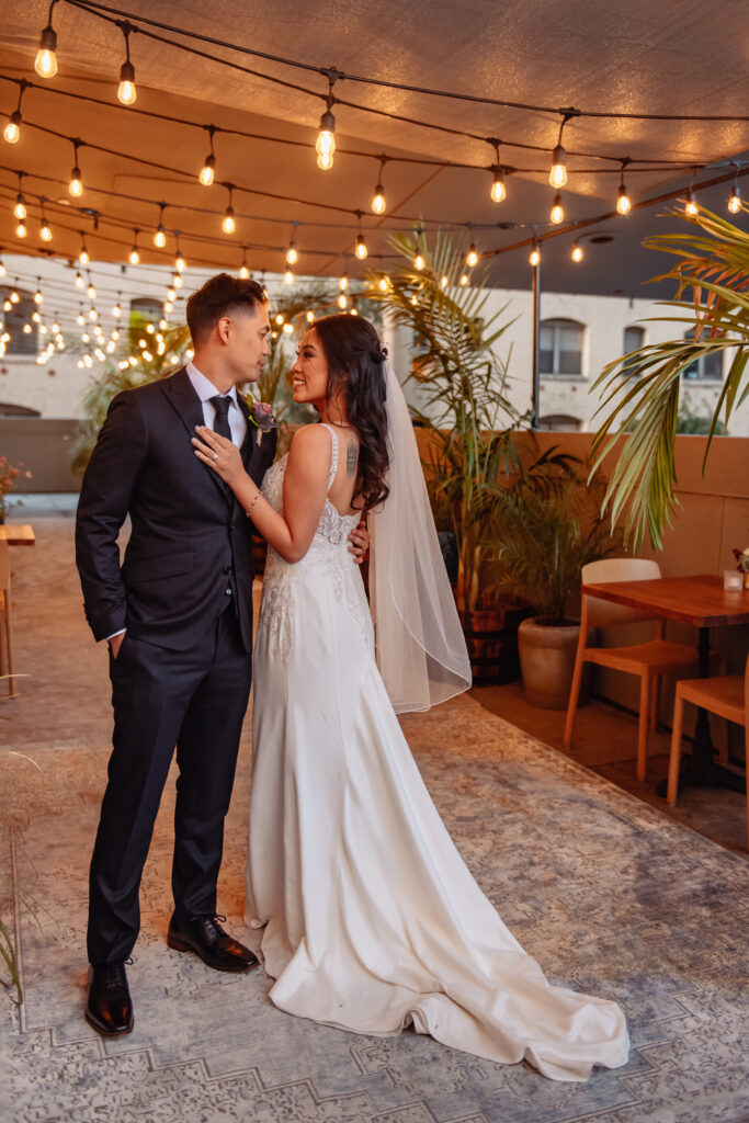 Couple posing with table chair in the background and lights