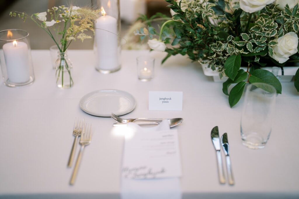 Plate with knife and spoon kept on the white table with f plantation
