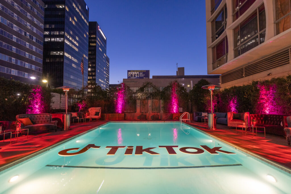 Tik tok written on the pool with sofa and table in the night with led lights
