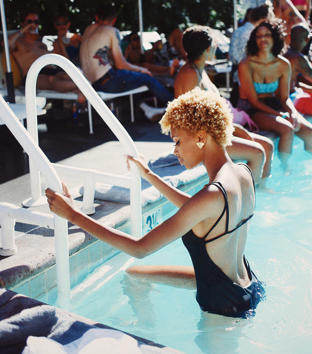Woman climbs up and out of a pool on a ladder