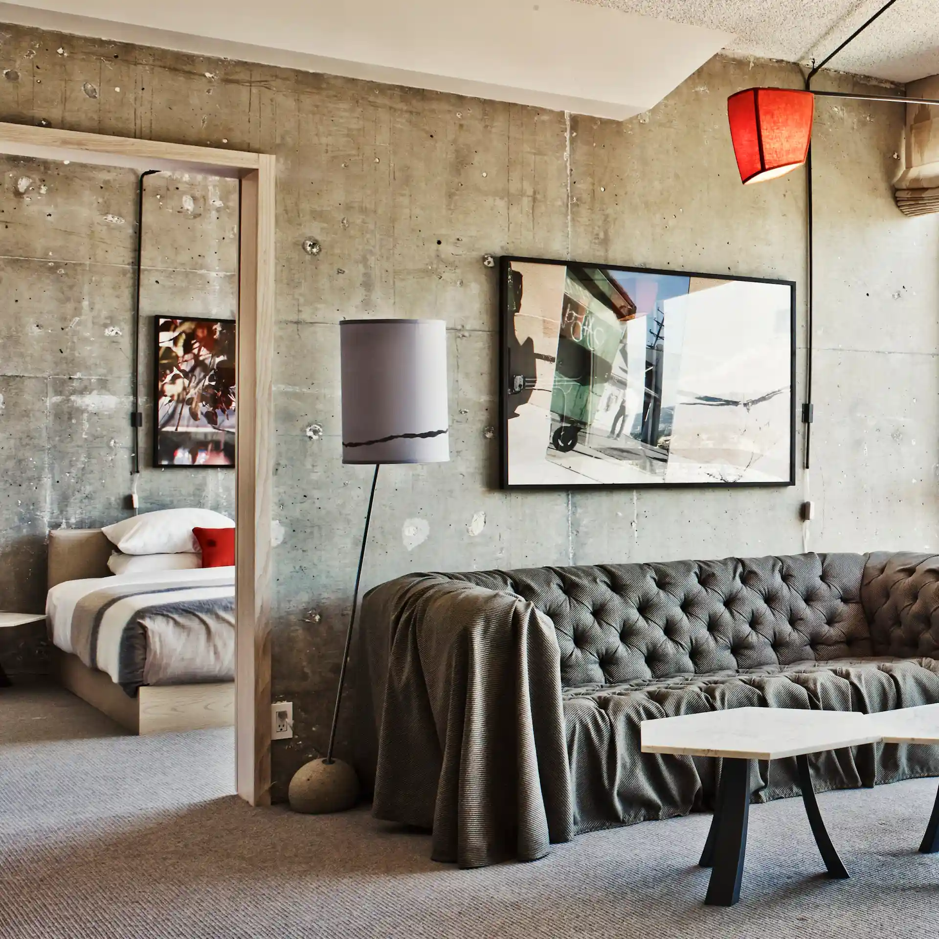 Picture of the Sofa with some lights , table and a door to bedroom.