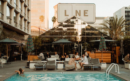Group of people lounging around a pool at the LINE LA