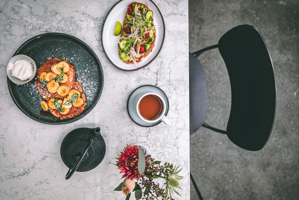 Aerial view of two breakfast dishes and a cup of coffee on the table