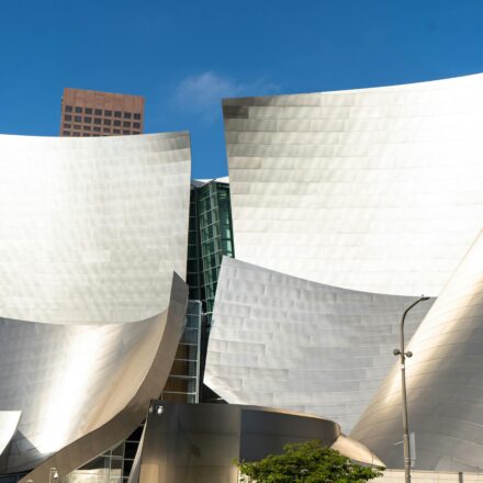 The metallic, curved architecture of the Walt Disney Concert Hall in bright daylight.