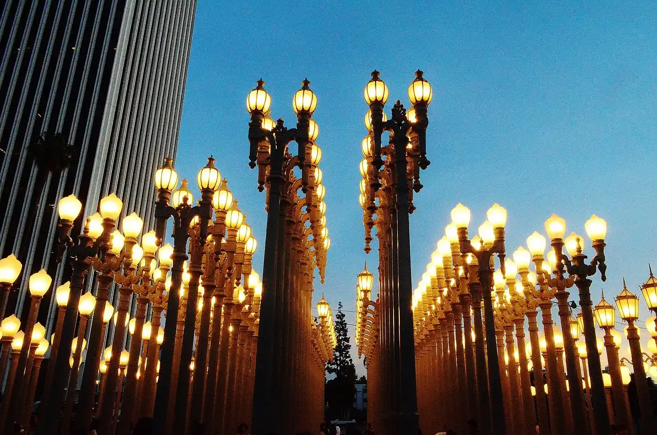 Rows of tall street lamps illuminated at dusk, likely part of the Urban Light installation at LACMA in LA