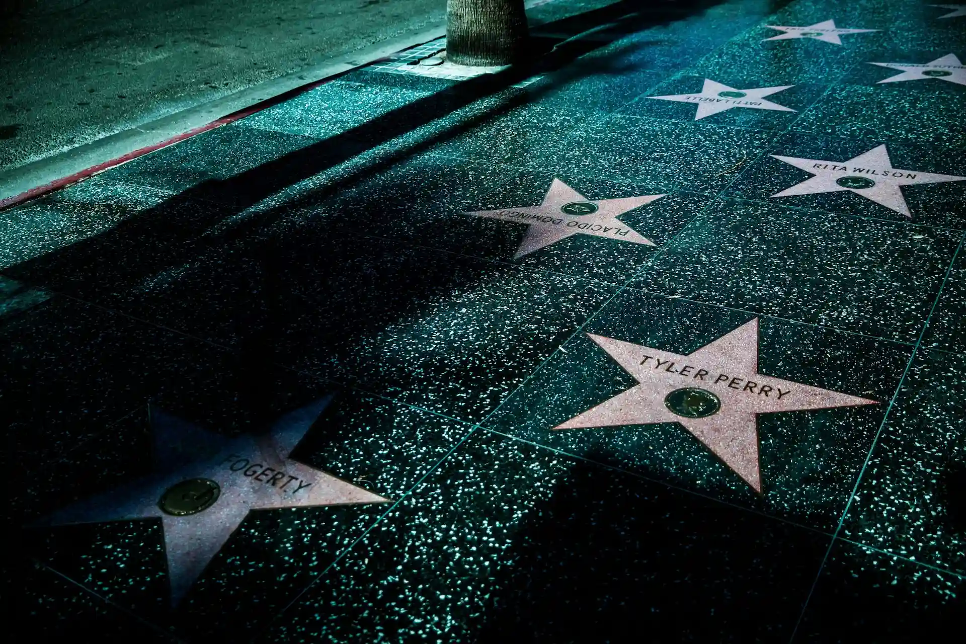 Hollywood Walk of Fame stars, including Tyler Perry and Rita Wilson, on a nighttime street