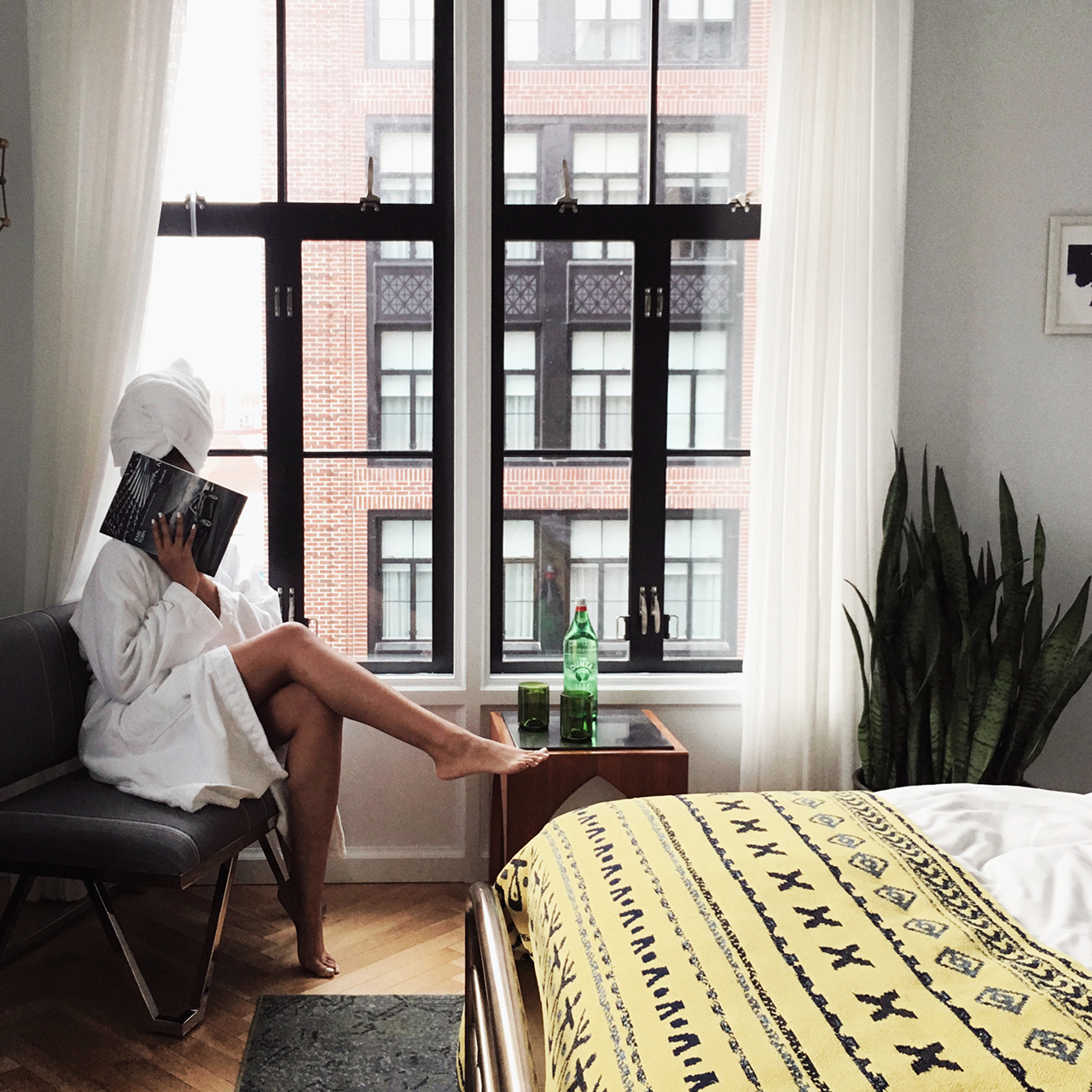 Picture of woman in towel hiding her face with book
