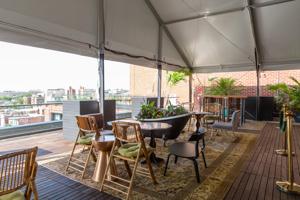 Picture of a tent shade balcony full of table and chairs along with green plants