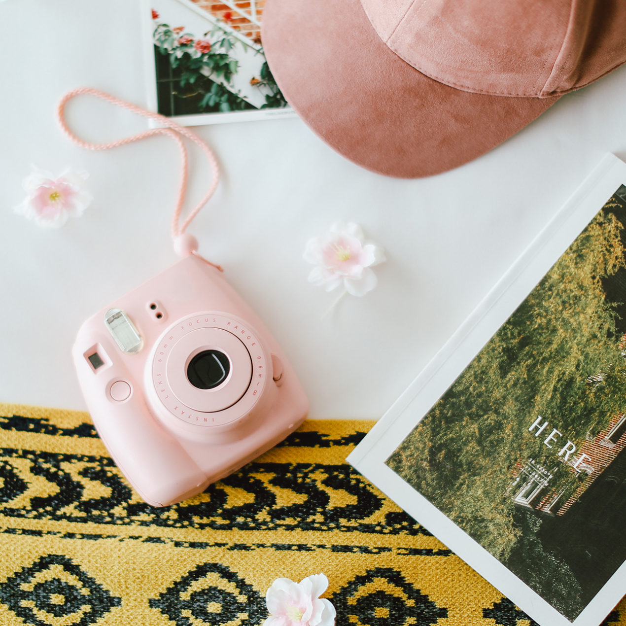 Picture of flower pink camera picture and a cap on the bed