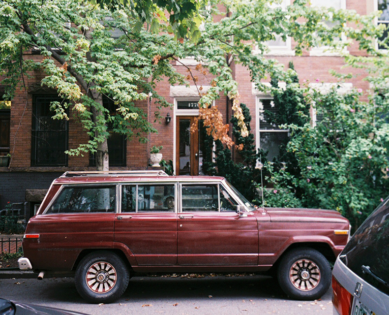 Picture of a red car with green Tree