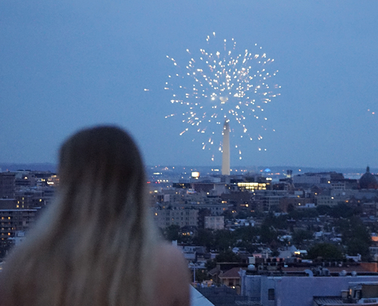A woman watching fire cracking with the city view from the terrace