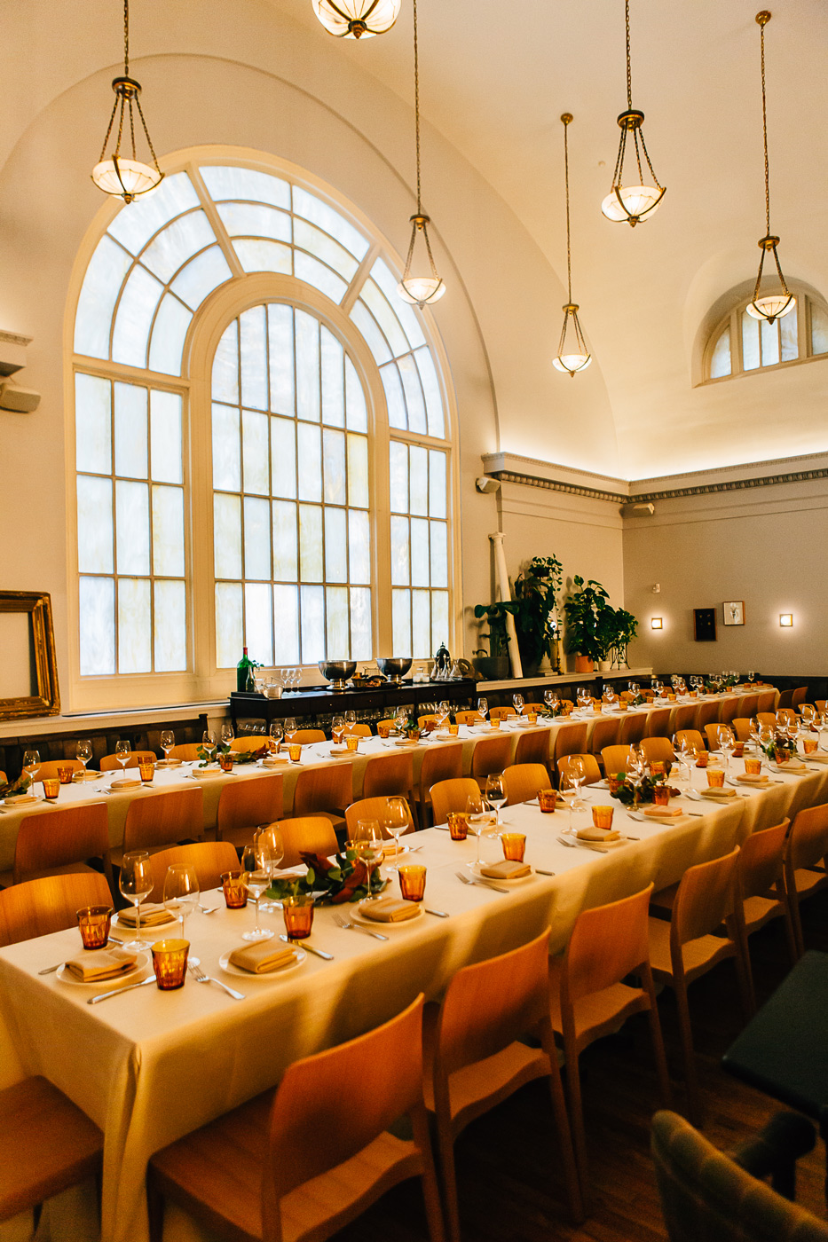 A long table set up with glasses and plates