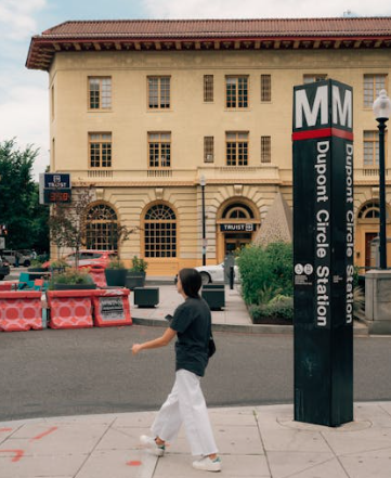 Person walking by Dupont Circle Metro Station sign in Washington, DC