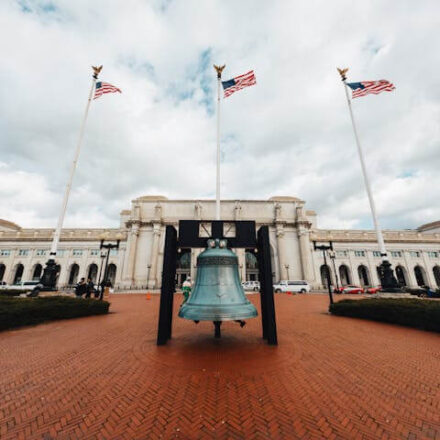 View of the large bell and American flags in front of Union Station, Washington DC