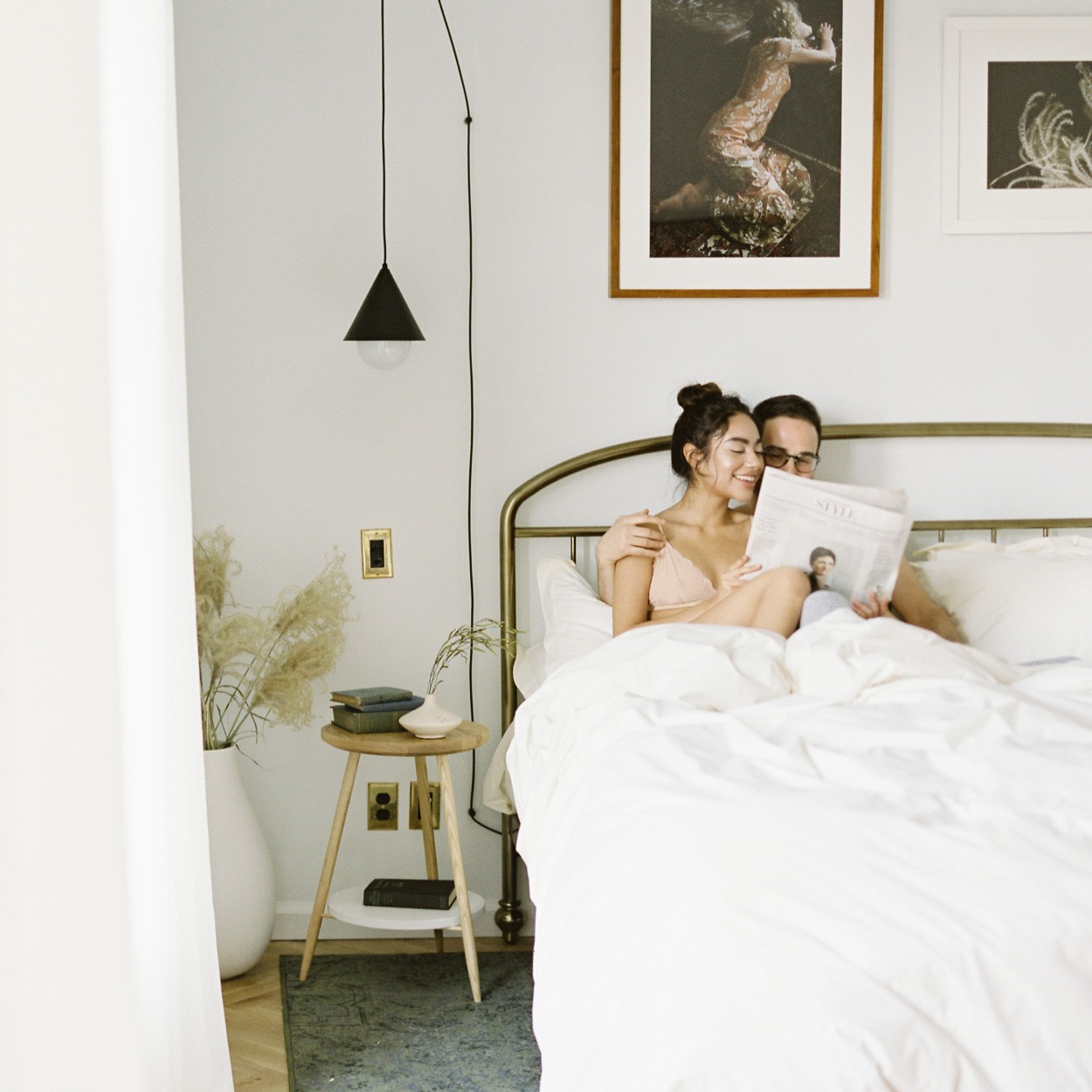 couple reading a newspaper in bed
