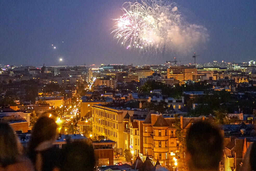 July 4th fireworks over Washington Monument viewed from the LINE DC rooftop with silhouetted spectators