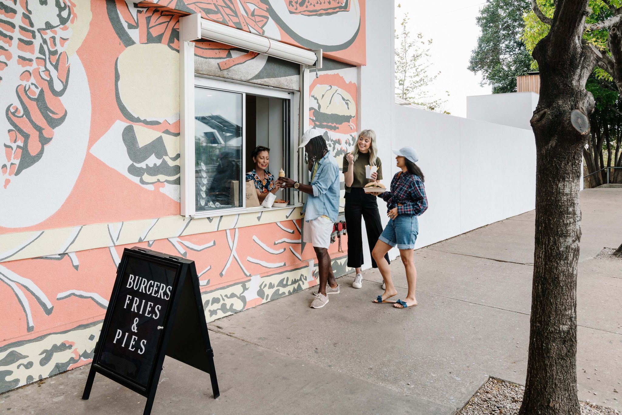People ordering food from an exterior takeaway window