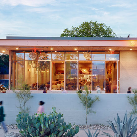 Picture of building with transparent glass window and having garden in front