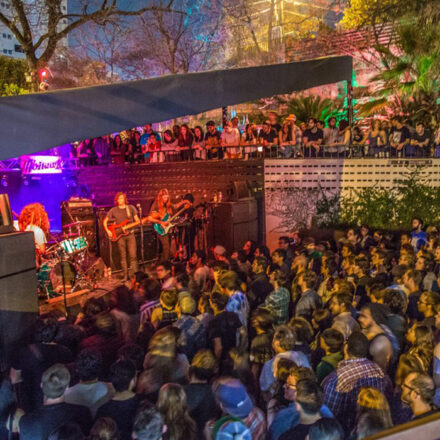 Live musical band performance under the shade with crowd