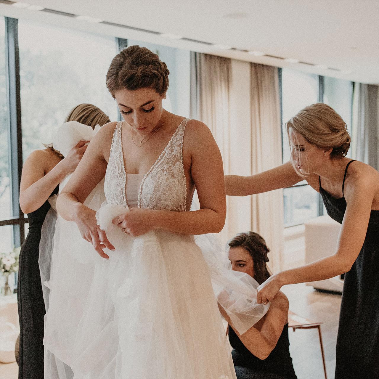 Girls helping a bride dress on her wedding day
